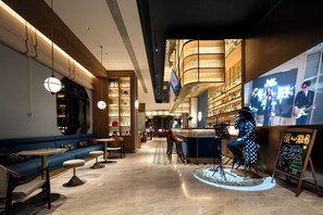 A modern bar area with seating, a television screen, and a bar counter. - Manxin Hotel Wuhan Hankou xinhua Road (Wuhan)