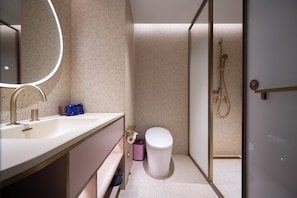 A modern bathroom with a white sink, a mirror, a shower, and a toilet. - Manxin Hotel Wuhan Hankou xinhua Road (Wuhan)