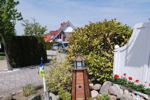 A residential area with a model lighthouse, a flag, and a house in the background. - Type 2 in the Schwardt house (Kellenhusen)