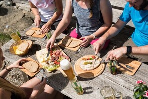 Un grupo de personas sentadas en una mesa de madera con diversos alimentos y bebidas.