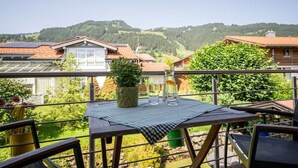 A balcony with a table, chairs, and a potted plant. - Holiday apartment with 1 bedroom (Bolsterlang)