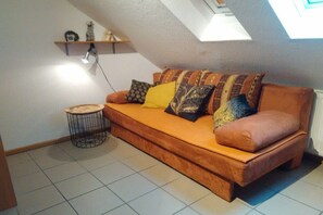 A cozy living room with a sofa, pillows, a small round table, and a wall-mounted shelf. - Holiday apartment with 3 bedrooms (Wehr-Öflingen)
