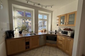 Eine Küche mit Holzausstattung, einer Mikrowelle, einer Kaffeemaschine und einem Spülbecken.