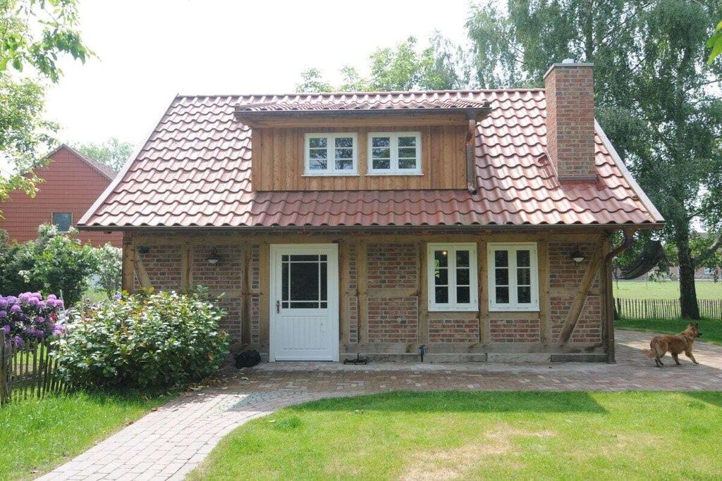A brick house with a tiled roof, a front door, and a small porch.