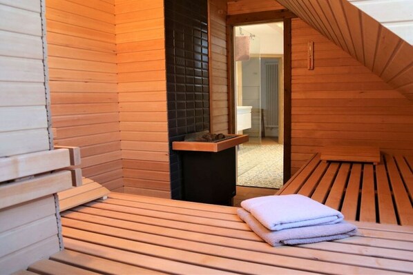 Una sauna con panche in legno e una panca con asciugamani.