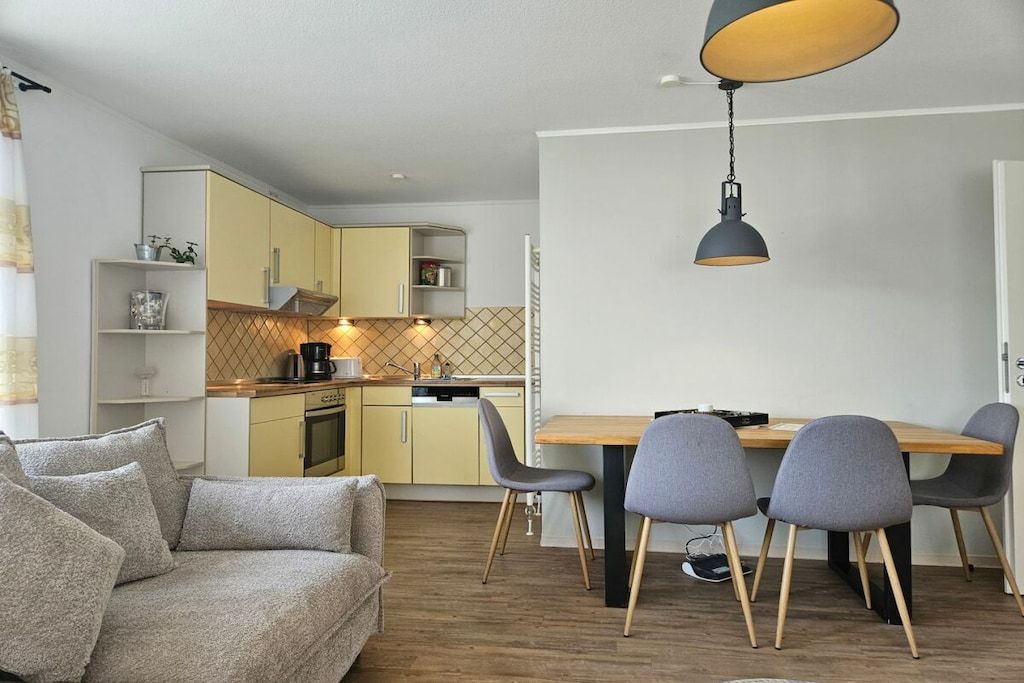 A modern kitchen with a dining area, including a sofa and chairs.