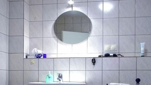 A bathroom with a sink, mirror, towel rack, and a toilet. - Holiday apartment with 1 bedroom (Eschweiler)