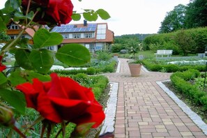 Ein Gartenweg führt zu einem Haus mit Solaranlage auf dem Dach.