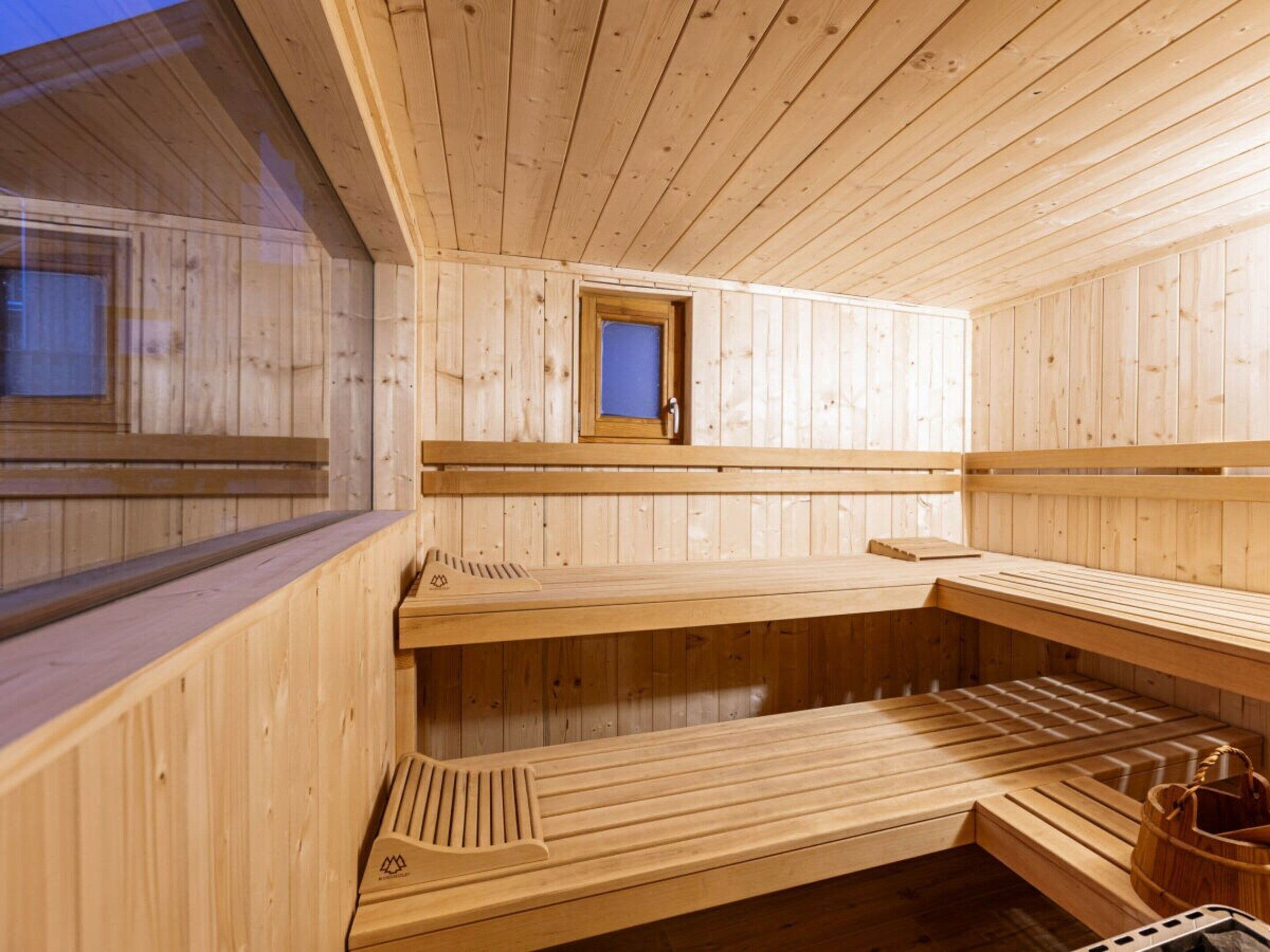 A wooden sauna with benches and a small window.