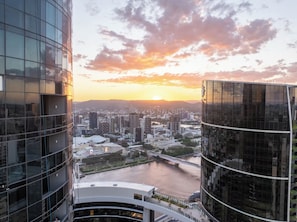 A cityscape with modern buildings, a river, and a sunset. - New Apt in Queens Wharf lv21 with Sofa bed (Brisbane City)