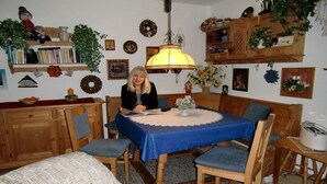 A cozy dining area with a table set for two, surrounded by wooden chairs and a bench. - Sauer with lake and alpine views (Immenstaad am Bodensee)
