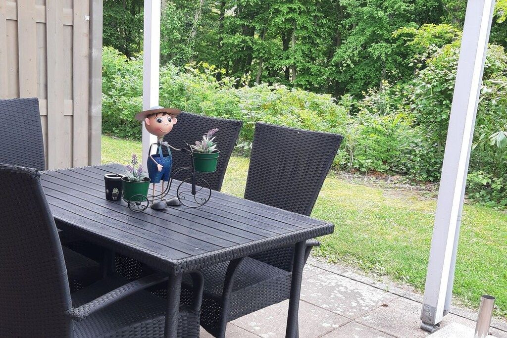 Une terrasse extérieure avec des meubles en osier et des plantes en pot.