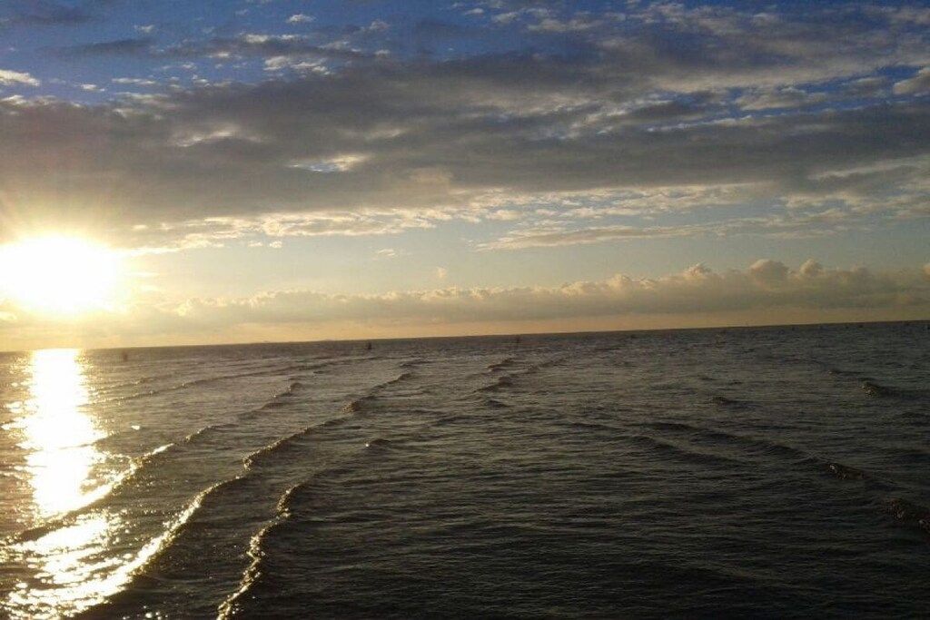 Una spiaggia con onde e un tramonto.