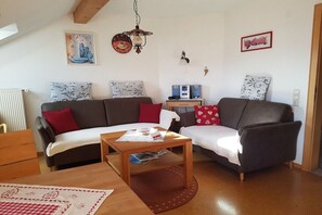 Ein gemütliches Wohnzimmer mit zwei Sofas, einem Couchtisch und einer Heizung.