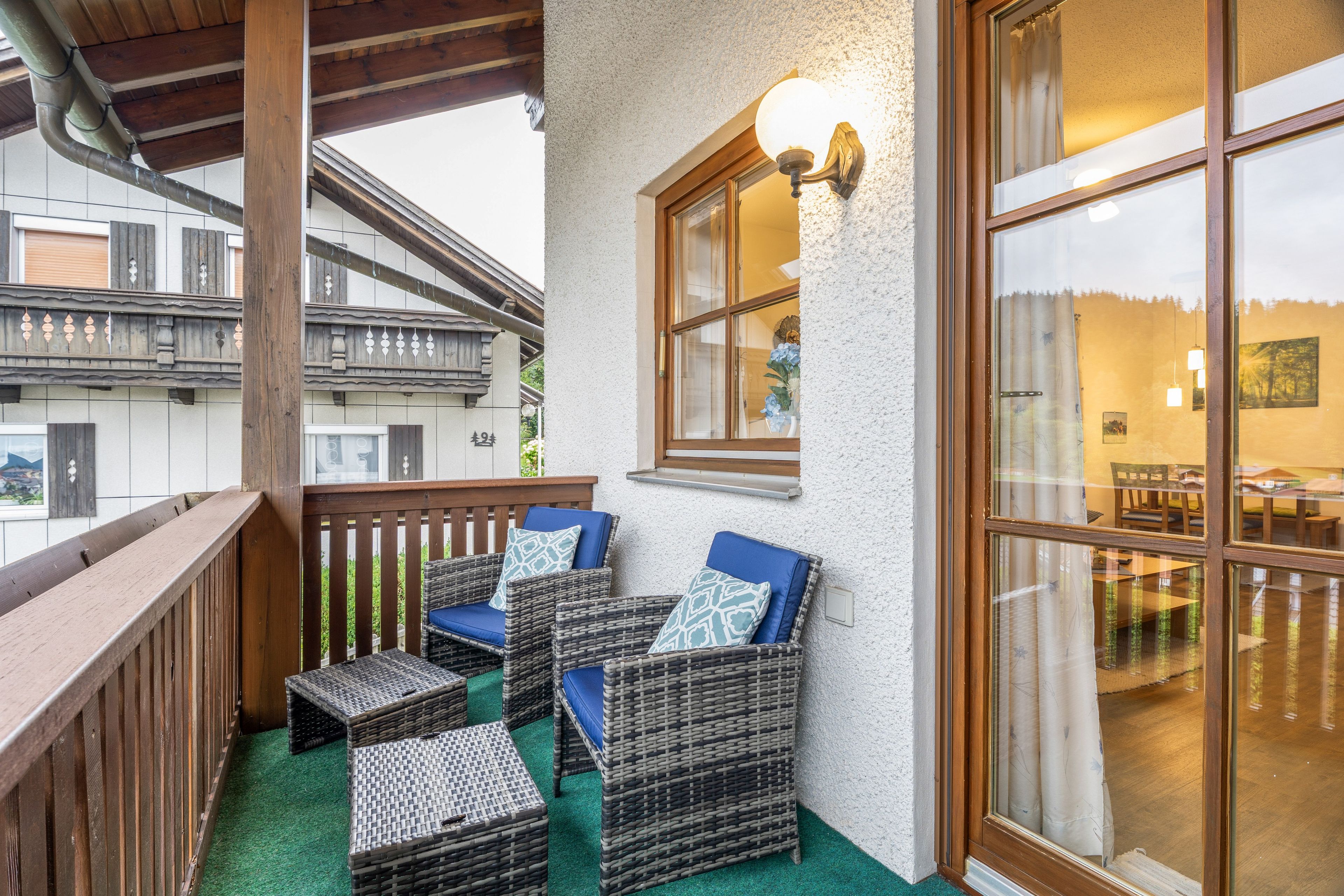 Ein Balkon mit Korbmöbeln und Blick ins Innere.