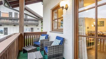 Ein Balkon mit Korbmöbeln und Blick ins Innere.