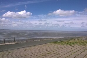 A paved walkway leading to a body of water with a clear sky above. - Holiday home with 2 bedrooms (Tossens\/Butjadingen)