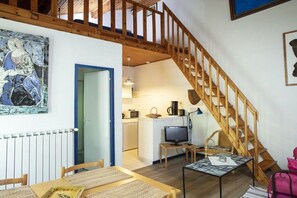 Ein gemütliches Interieur mit Essbereich, Küche und einer Holztreppe.