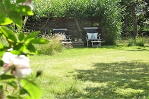 A grassy outdoor area with two lounge chairs and a wooden structure in the background. - Holiday apartment with 5 bedrooms (Lauterbach)