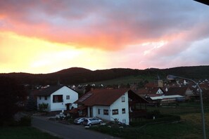 Ein Wohngebiet mit Häusern, einer Straße und einer Hügelkulisse im Hintergrund.