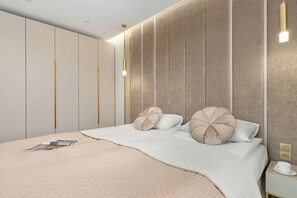 Une chambre moderne avec un grand lit, une table de chevet et une armoire.