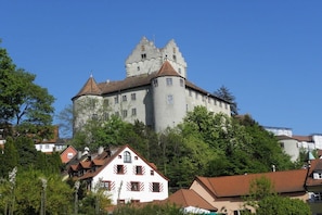 A castle-like building with multiple towers and a prominent central tower, surrounded by residential houses with red roofs. - Holiday apartment in Salem with swimming pool (Salem)