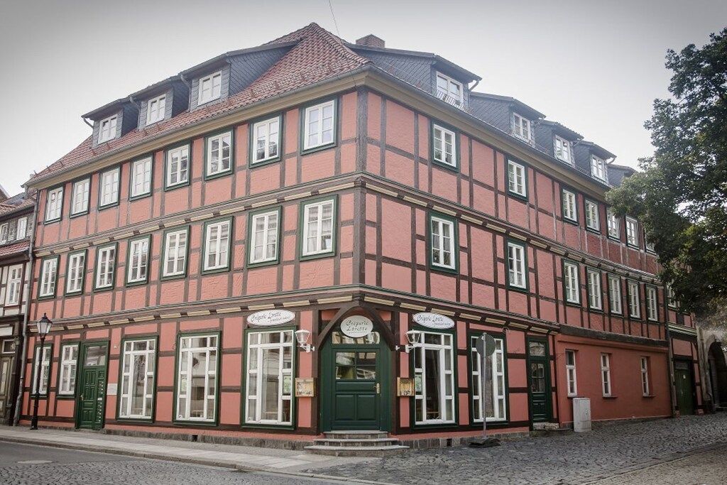 A traditional European building with a symmetrical facade, multiple windows, and a central entrance with a green door.