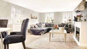Una sala de estar moderna con un sofá, sillones, una mesa de centro y una chimenea.