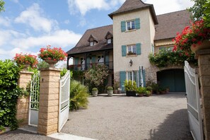 A two-story house with a gravel driveway, a gated entrance, and a garage. - Le Petit Chateau: house with private pool, Wi-Fi and air conditioning (Bétaille)