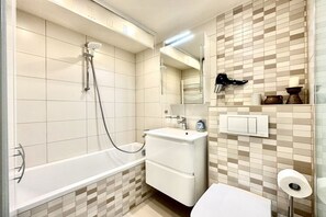 Ein Badezimmer mit Badewanne, Waschbecken, Spiegel und Toilette.