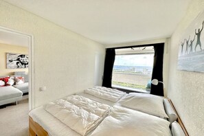 Ein Schlafzimmer mit einem großen Bett, einem Fenster mit Ausblick und einem Bild an der Wand.