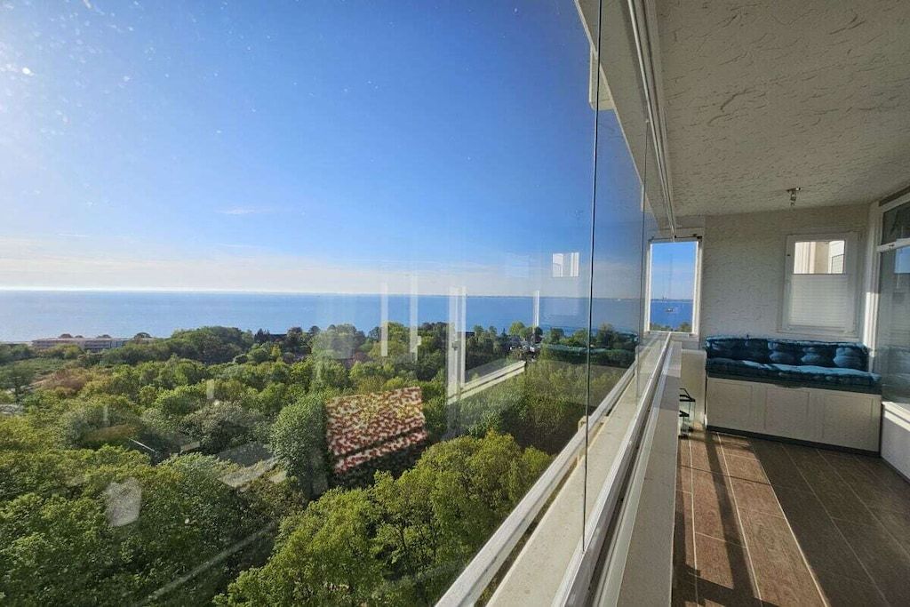 Un balcon offrant une vue dégagée sur la mer et la végétation environnante.