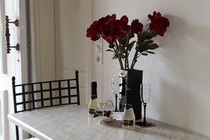 A table with a vase of red roses, two wine bottles, and two wine glasses. - Villa Maja Lake Constance (Markdorf)