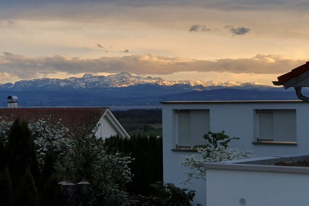 Ein Wohngebäude mit Blick auf schneebedeckte Berge im Hintergrund.
