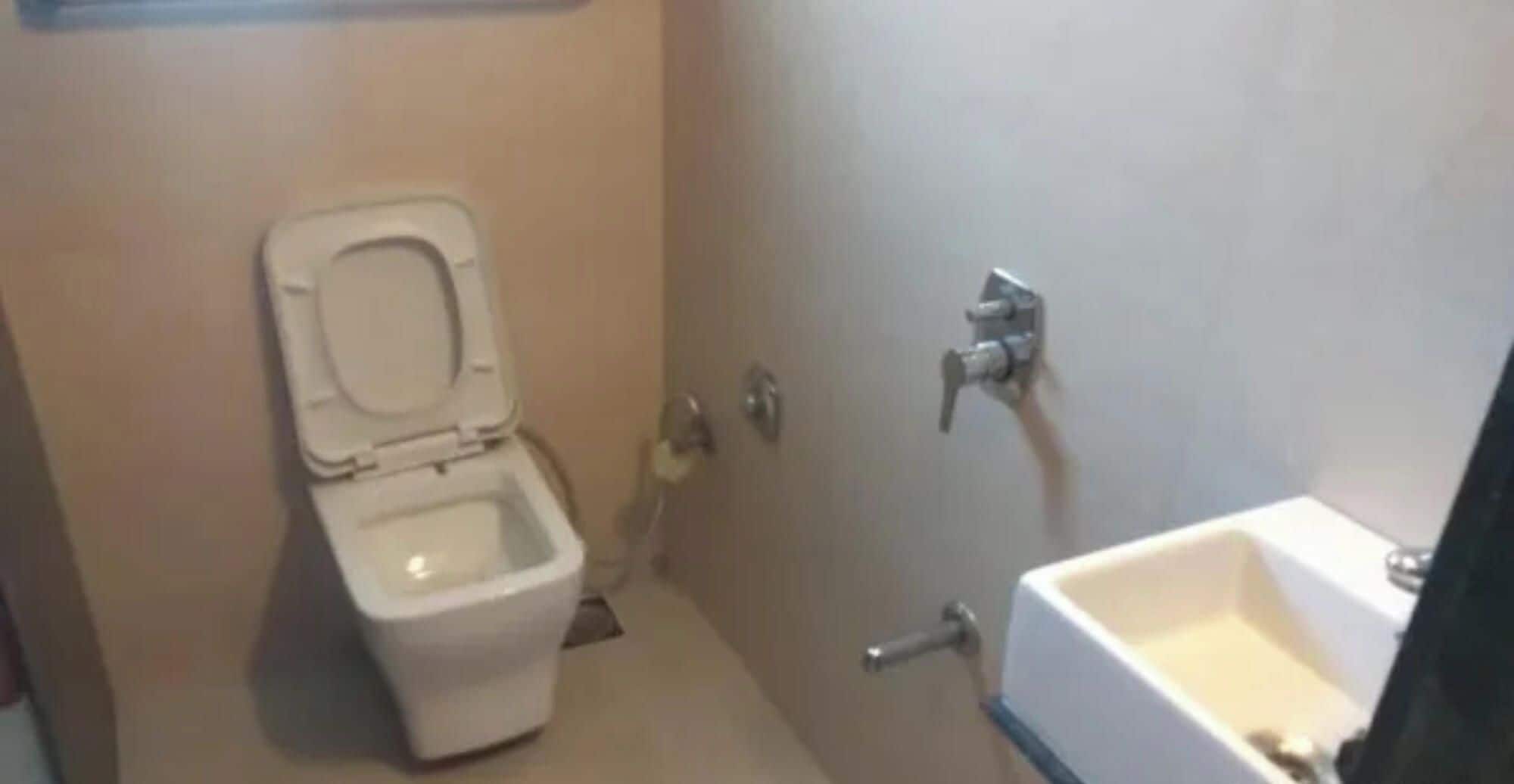 Een kleine badkamer met toilet, wastafel en douche.