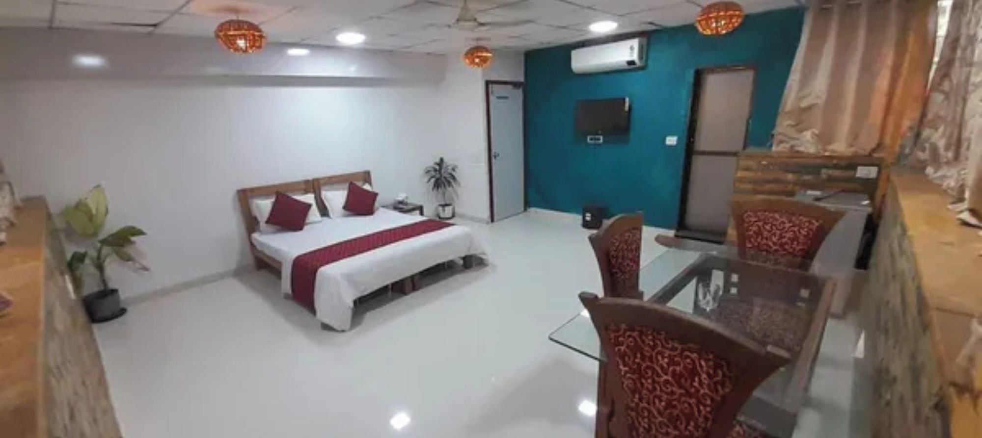 A hotel room with a bed, a desk, and two chairs.