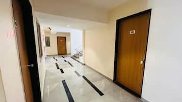 A hotel corridor with a wooden door marked '101' and a tiled floor with black stripes.