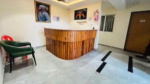 Una recepción con un escritorio de madera, un ventilador de techo y una puerta.