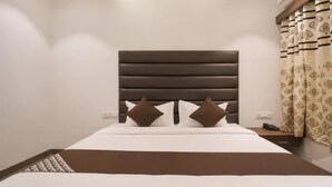 A hotel room with a bed, a headboard, and curtains. - Fabhotel Rudraksh Inn (Indore)