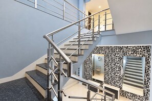 A modern staircase with metal railings and a patterned wall design. - FabHotel Rudraksh Inn (Indore)