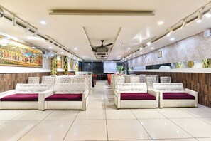 A hotel lobby with a central seating area, a ceiling fan, and a mural on the wall. - FabHotel Rudraksh Inn (Indore)