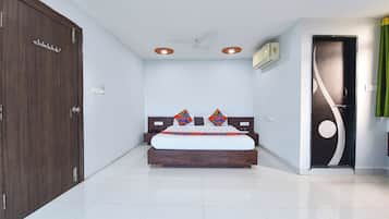Habitación de hotel con cama, armario, ventilador de techo y una puerta con cortina.