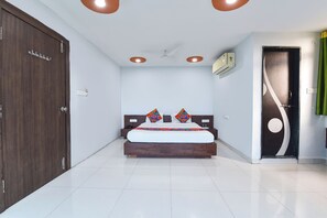 Habitación de hotel con cama, armario, ventilador de techo y una puerta con cortina.