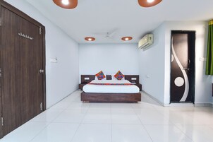 Habitación de hotel con cama, armario, ventilador de techo y una puerta con cortina.