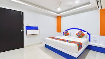 Un dormitorio moderno con cama, mesitas de noche, ventilador de techo y una puerta.