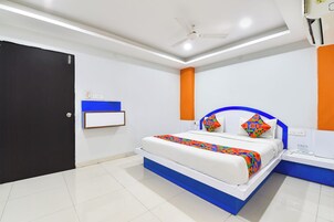 Un dormitorio moderno con cama, mesitas de noche, ventilador de techo y una puerta.