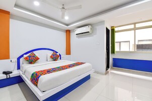 Habitación de hotel con cama, teléfono, aire acondicionado y ventana.