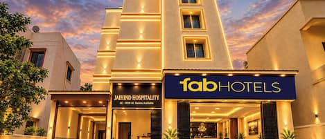 A hotel entrance with a sign for 'fabHOTELS' and 'JAIHIND HOSPITALITY' indicating available rooms.