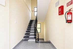 Una escalera con un carrete de manguera contra incendios y un letrero de salida.