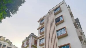 Un edificio residencial de varios pisos con fachada plana, varias ventanas y una entrada visible.